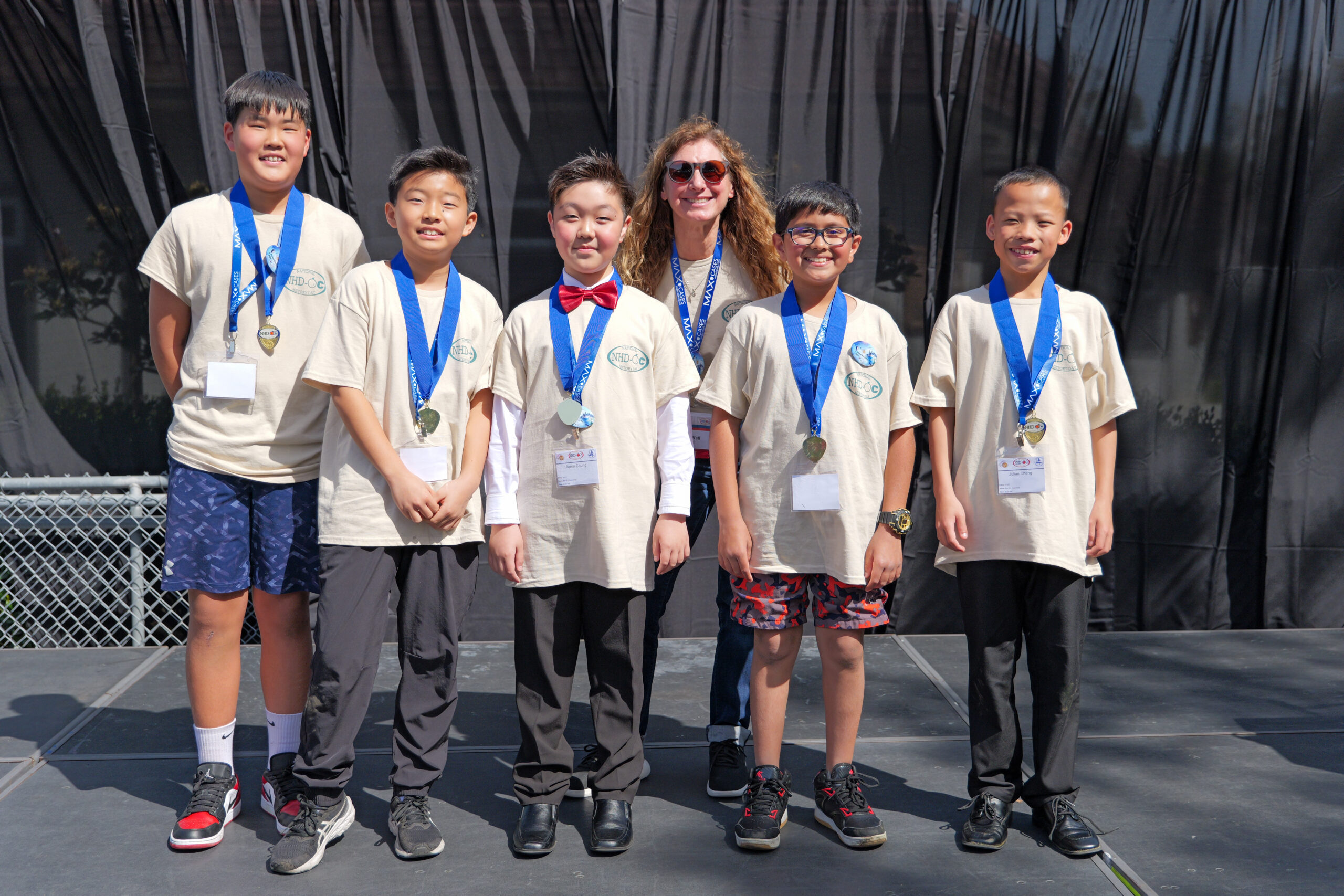 Students stand with Julie Hull, OCDE’s coordinator of National History Day-OC, during the 2024 National History Day-Orange County competition.