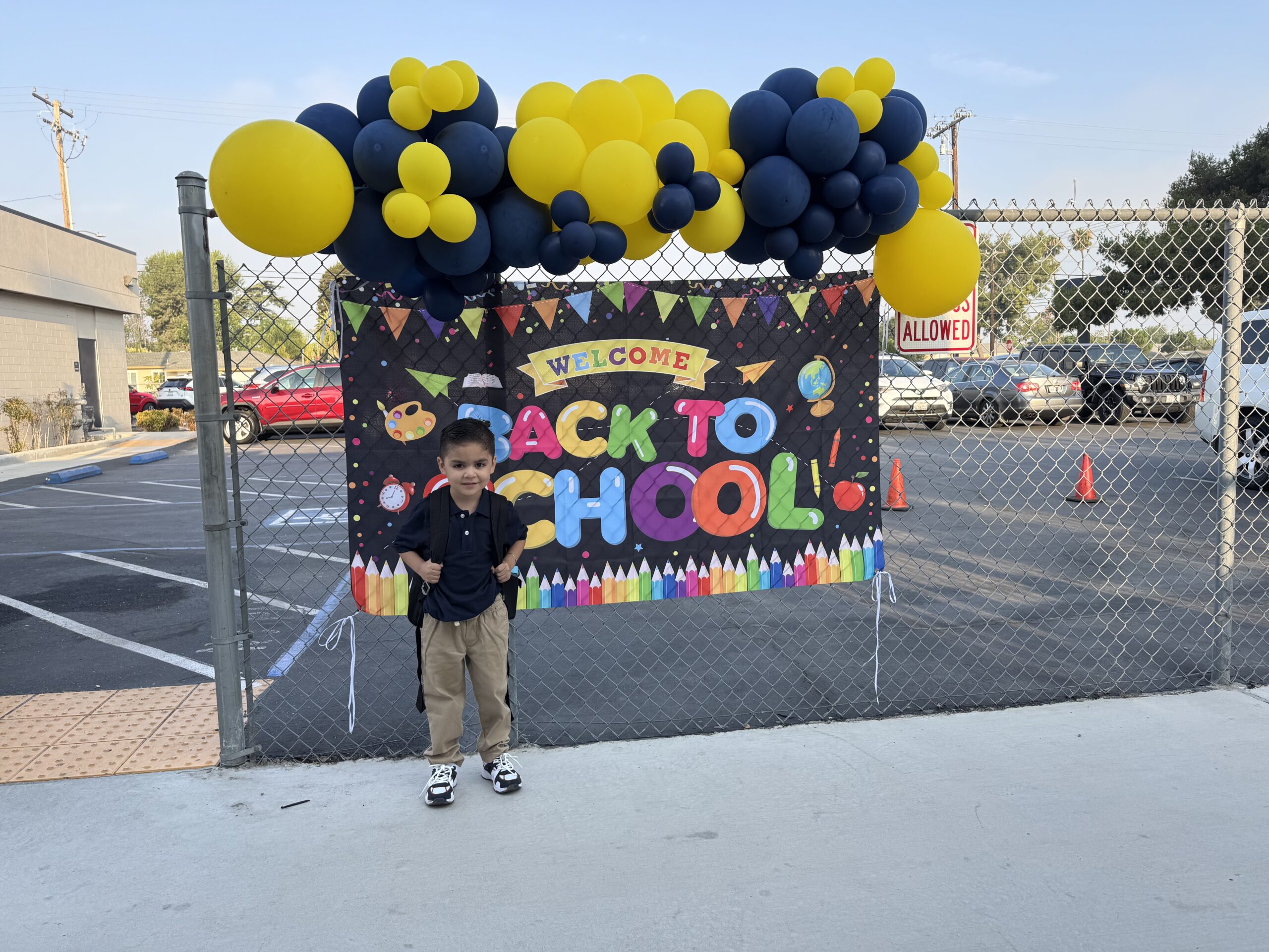 Student James Tiscareno stands beside a welcome sign on the first day of school at Thomas Edison Elementary in Anaheim.