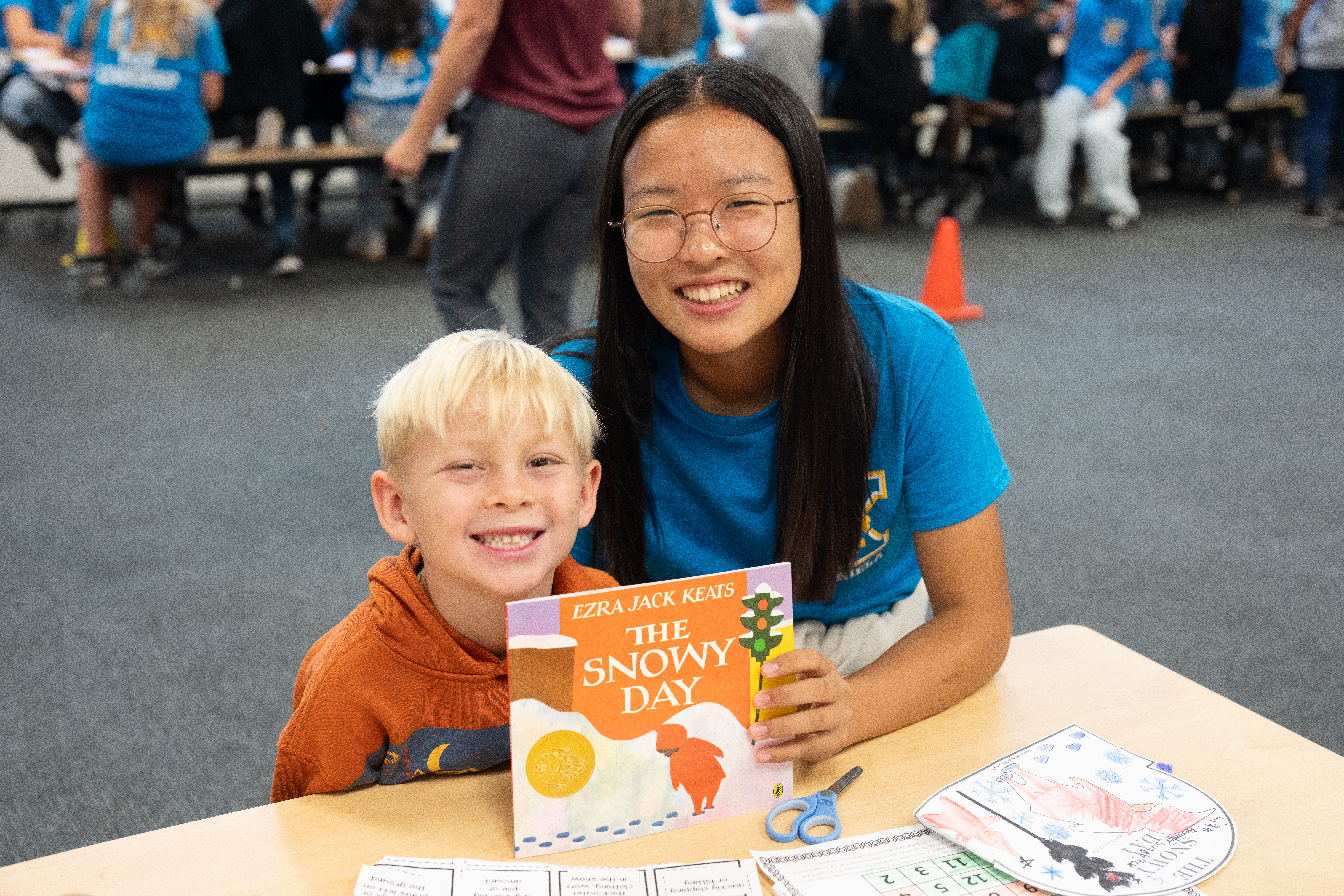 Buddies pose with “The Snowy Day” by Ezra Jack Keats.
