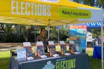 A representative from the Orange County Registrar of Voters shares voter registration information with attendees at the San Juan Summer Nights Concert series in San Juan Capistrano on June 18.