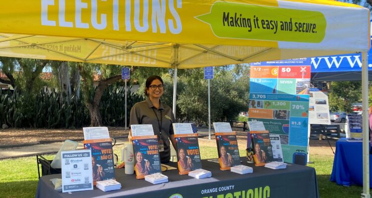 A representative from the Orange County Registrar of Voters shares voter registration information with attendees at the San Juan Summer Nights Concert series in San Juan Capistrano on June 18.