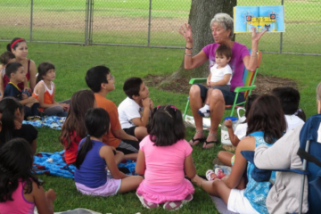 Teacher Leslee Milch reads to children and families