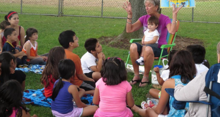 Teacher Leslee Milch reads to children and families