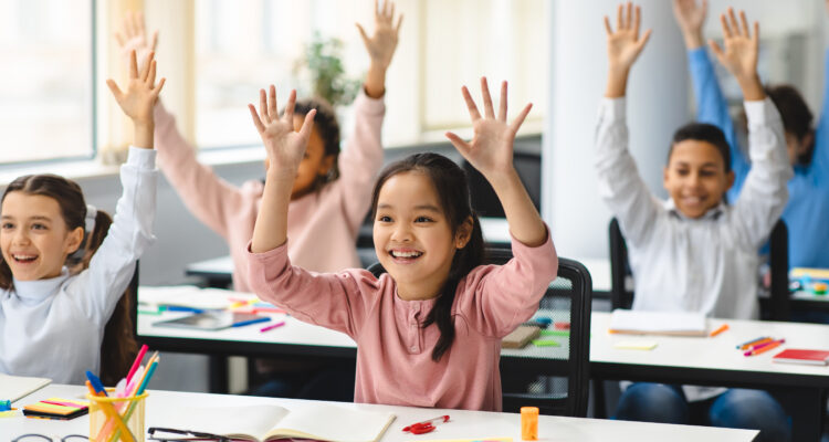 Students raising their hands in class