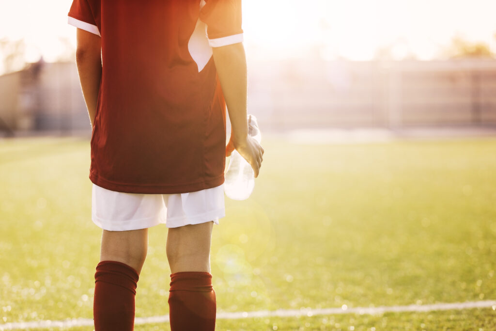 Soccer player standing in the sun