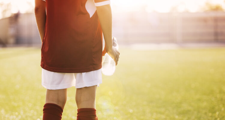 Soccer player standing in the sun