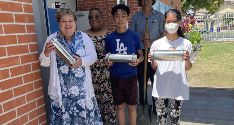 Students and staff from DeMille Elementary School hold their time capsules.