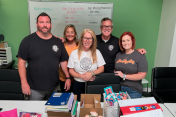 Huntington Beach High School administrators join Project Hope Alliance CEO Jennifer Friend to fill backpacks with school supplies.