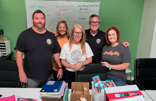 Huntington Beach High School administrators join Project Hope Alliance CEO Jennifer Friend to fill backpacks with school supplies.