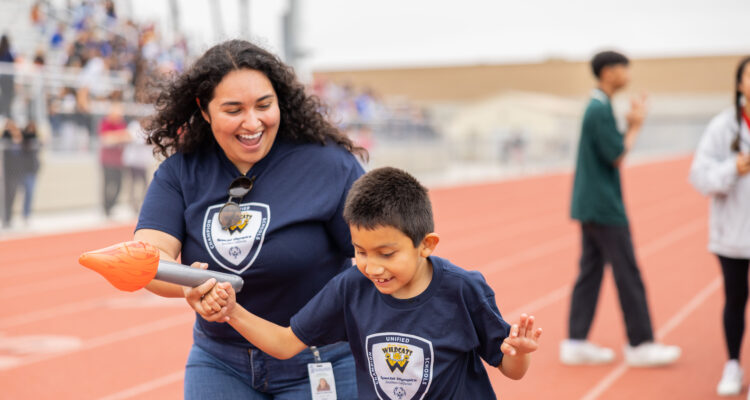 Warren Elementary School student Isaiah Ramirez competes in the torch relay event with support from Instructional Aide Yaritza Mercado at the 52nd Special Games at Bolsa Grande High School on May 19. (Photos courtesy of Garden Grove Unified School District)