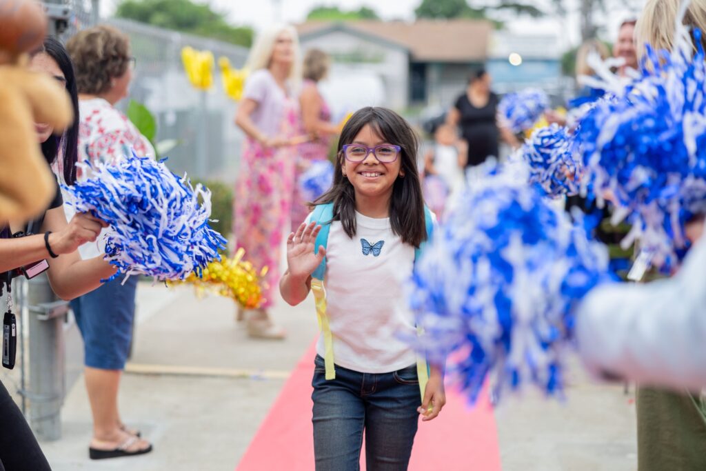 A Clinton Elementary School student is cheered on by teachers and staff as they arrive on campus. (Courtesy of Garden Grove Unified)