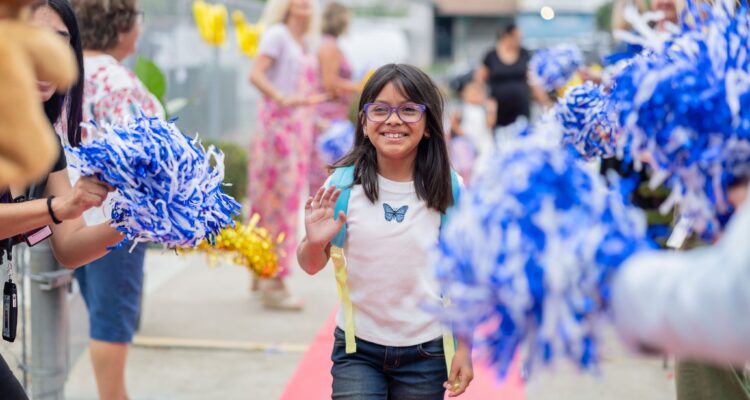 A Clinton Elementary School student is cheered on by teachers and staff as they arrive on campus. (Courtesy of Garden Grove Unified)