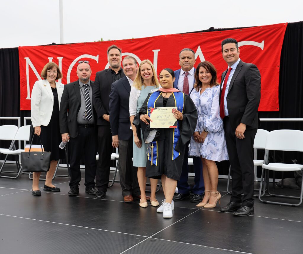 Martha Trujillo earns her honorary certificate of promotion on May 31. She is pictured with Superintendent Dr. Robert Pletka and Nicolas Jr. High Principal Jose Varela among district board members and staff. (Fullerton School District) 