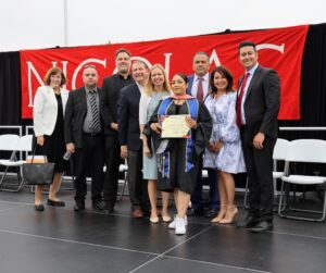 Martha Trujillo earns her honorary certificate of promotion on May 31. She is pictured with Superintendent Dr. Robert Pletka and Nicolas Jr. High Principal Jose Varela among district board members and staff. (Fullerton School District)