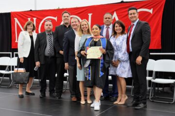 Martha Trujillo earns her honorary certificate of promotion on May 31. She is pictured with Superintendent Dr. Robert Pletka and Nicolas Jr. High Principal Jose Varela among district board members and staff. (Fullerton School District)