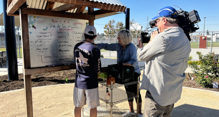 Educator Marianne Taylor discusses garden tasks with a student at Harbor Learning Center South Campus in Fountain Valley, while being filmed by KCAL News for a segment on Nov. 2, 2023.