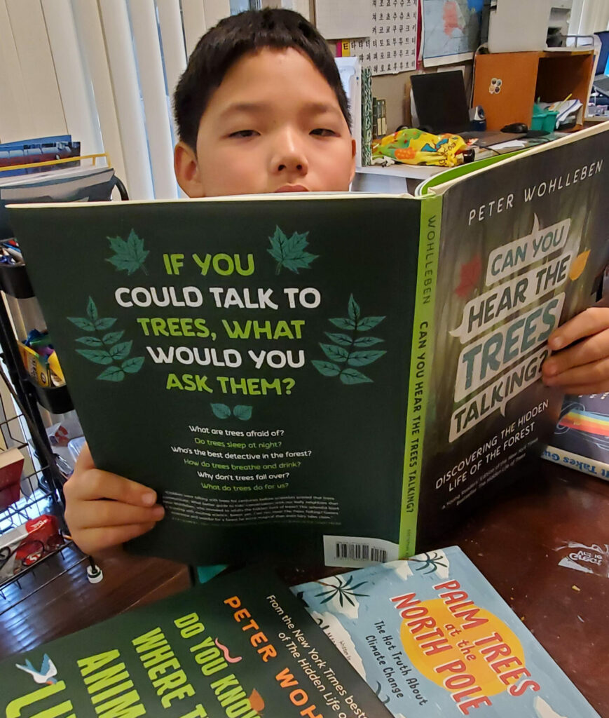 Student Daniel Lee reads books for the STEAM Race to Space Reading Challenge.