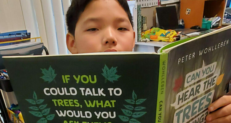 Student Daniel Lee reads books for the STEAM Race to Space Reading Challenge.