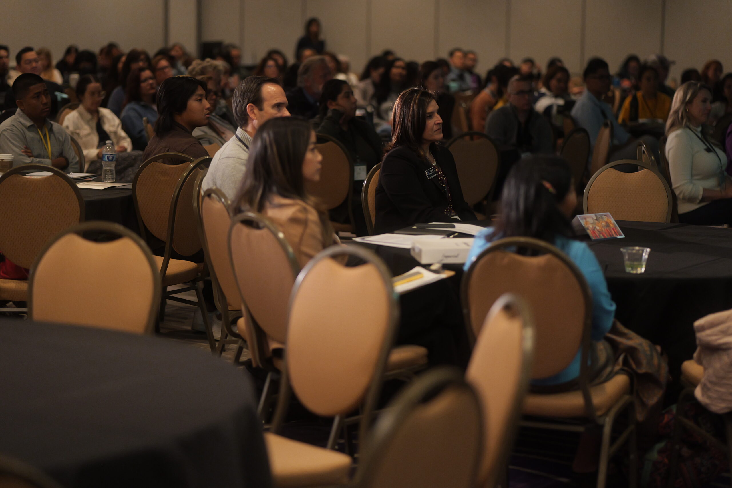 Dr. Sonia Llamas, OCDE Chief Academic Officer of Educational Services, sits with Dr. Jonathan Swanson and Tori Phu from the model curriculum team as they listen intently to the keynote speech during the Cambodian American Studies Model Curriculum Conference.