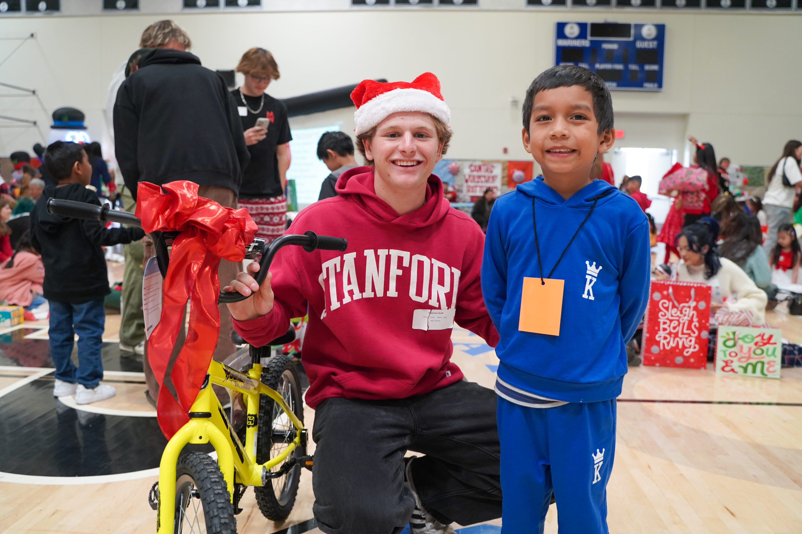 A Pacifica High senior poses with a bike alongside a kindergarten student