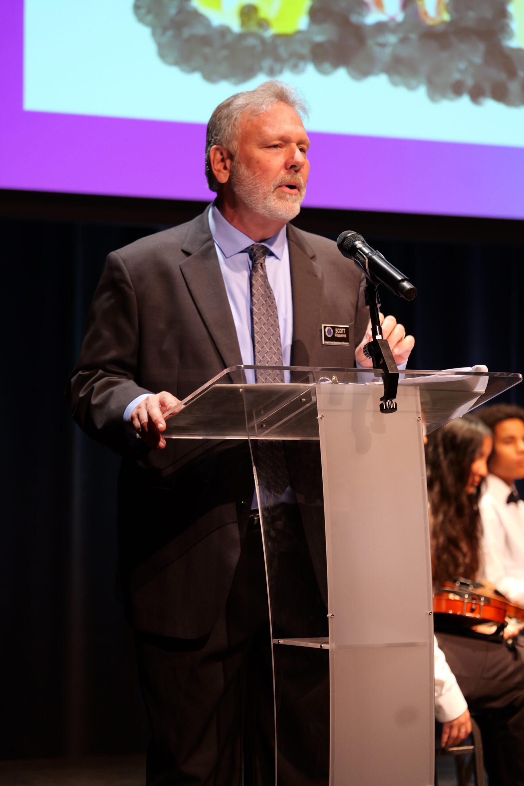 Scott Fitzpatrick, arts coordinator for the Orange County Department of Education, speaks at the 2025 Orange County Music and Arts Administrators Awards ceremony.