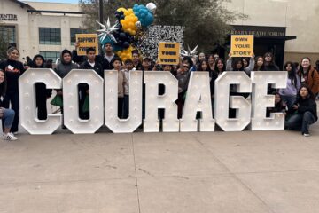 Students pose with "Courage" sign