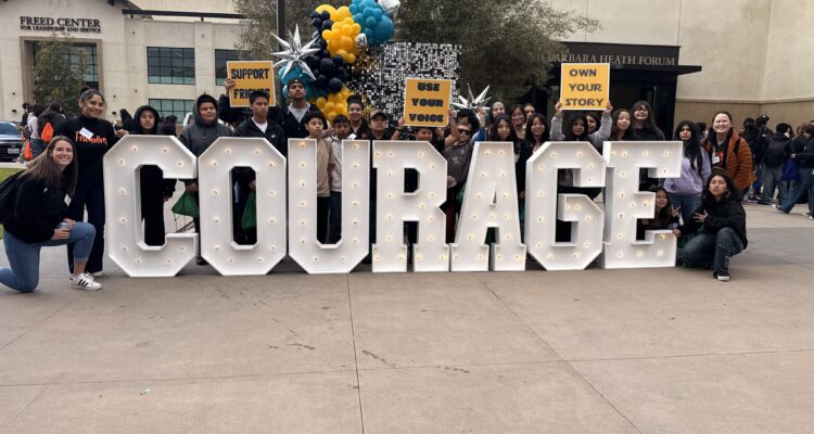 Students pose with "Courage" sign