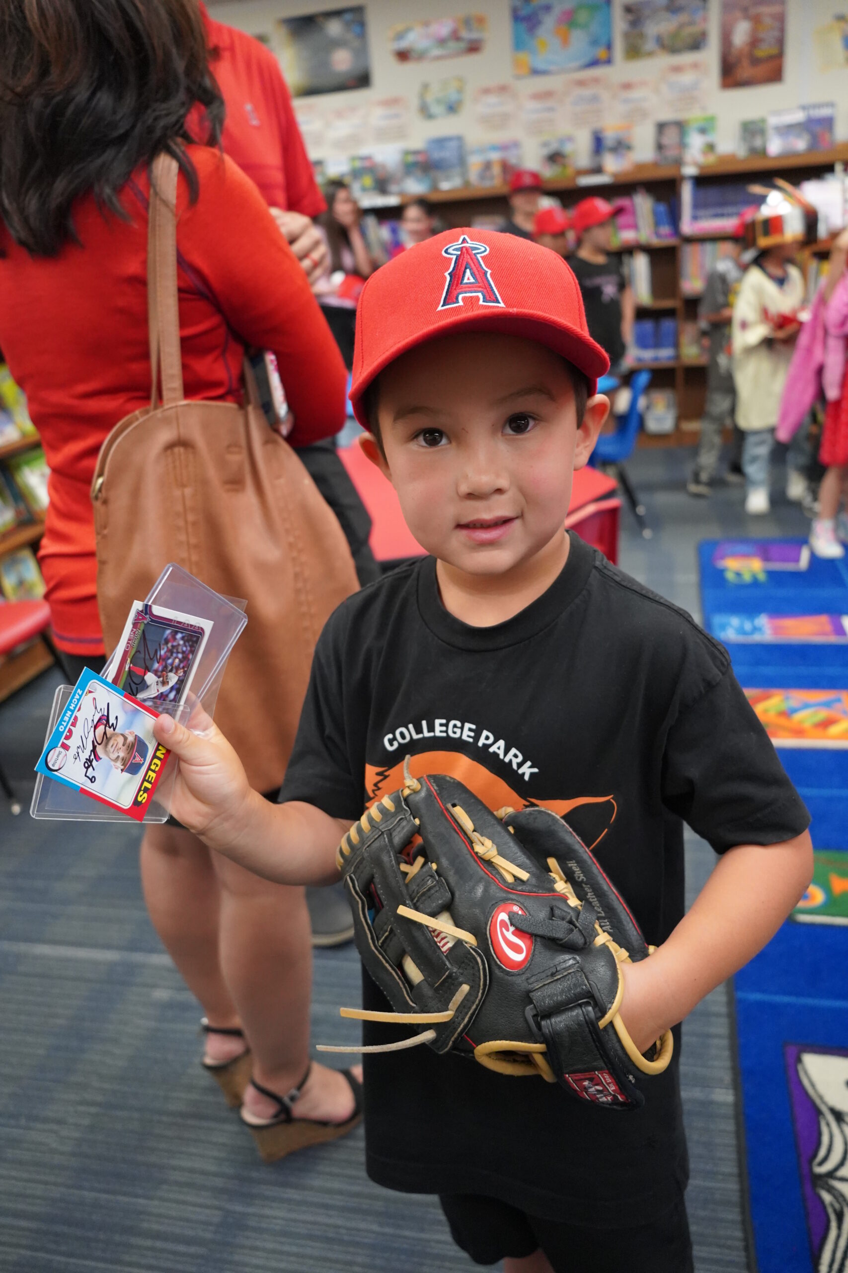 A College Park Elementary School student gets his baseball cards signed by Zach Neto at a special meet-and-greet on campus May 9. (Angels Baseball Foundation) 
