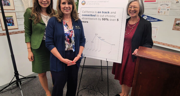 Sujie Shin, Jami Parsons and Cecelia Leong stand in front of a poster highlighting California’s commitment to cut chronic absenteeism by 50 percent over five years.