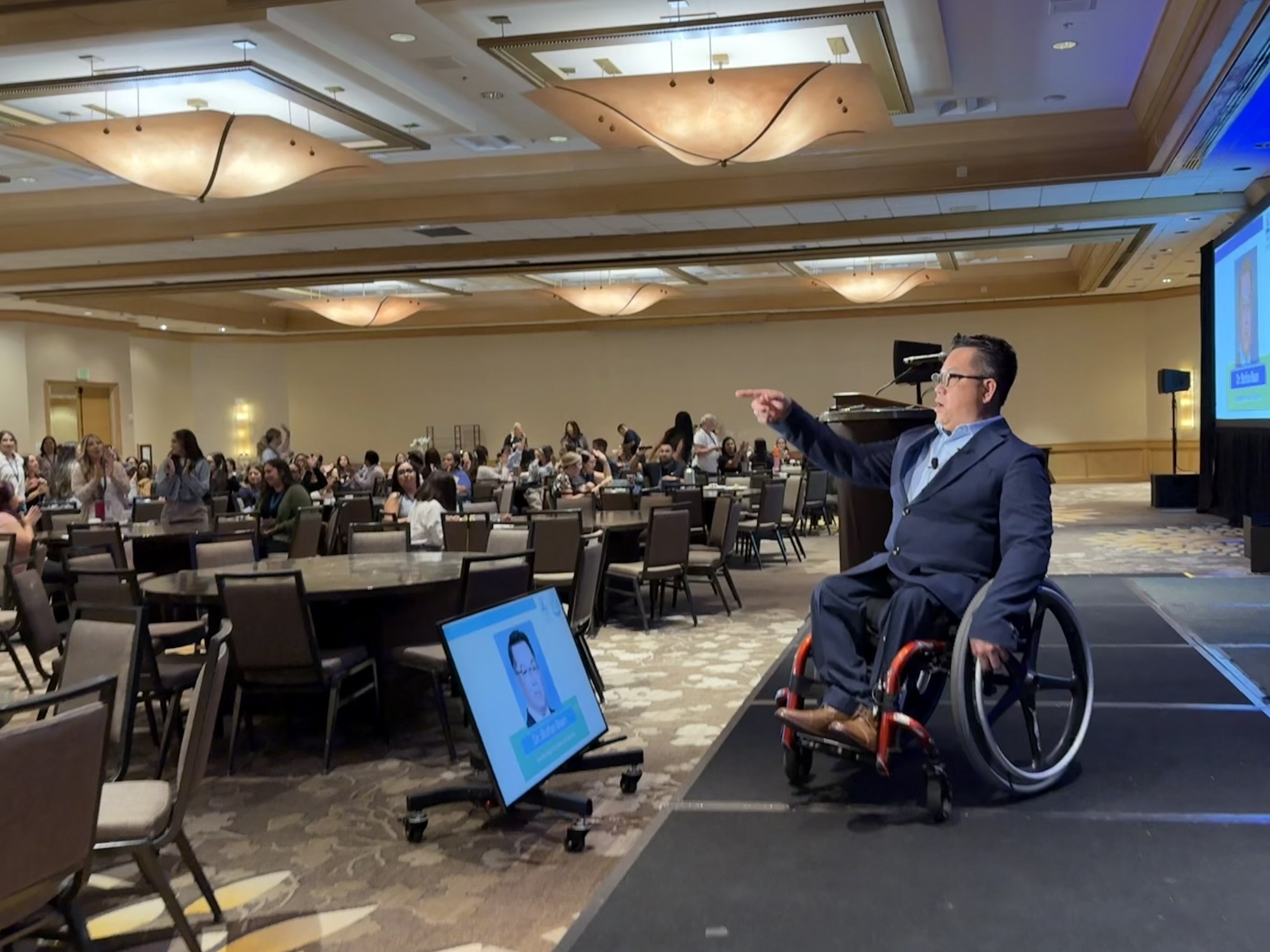 Dr. Stefan Bean speaks from the stage to an audience of mental health professionals at the School-Based Mental Health Summit in Costa Mesa.