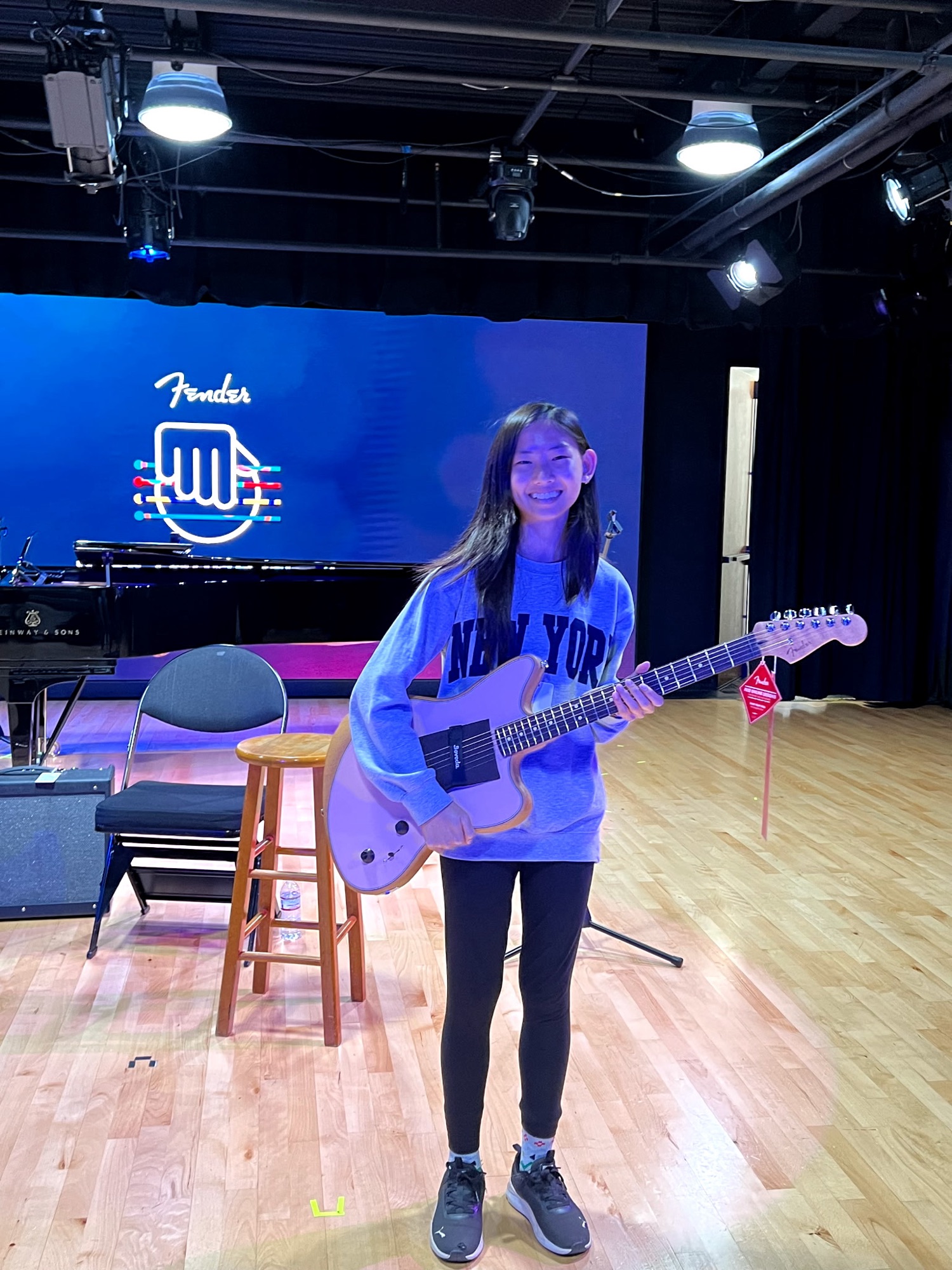 High school student Allison Chang holds a Fender Acoustasonic Player Jazzmaster guitar on stage at OC Music & Dance.