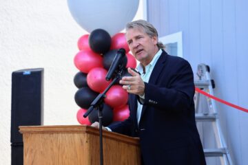 Dr. Bob Pletka, superintendent of Fullerton School District, speaking at a podium during the district’s second Tiny Home Project ribbon-cutting ceremony