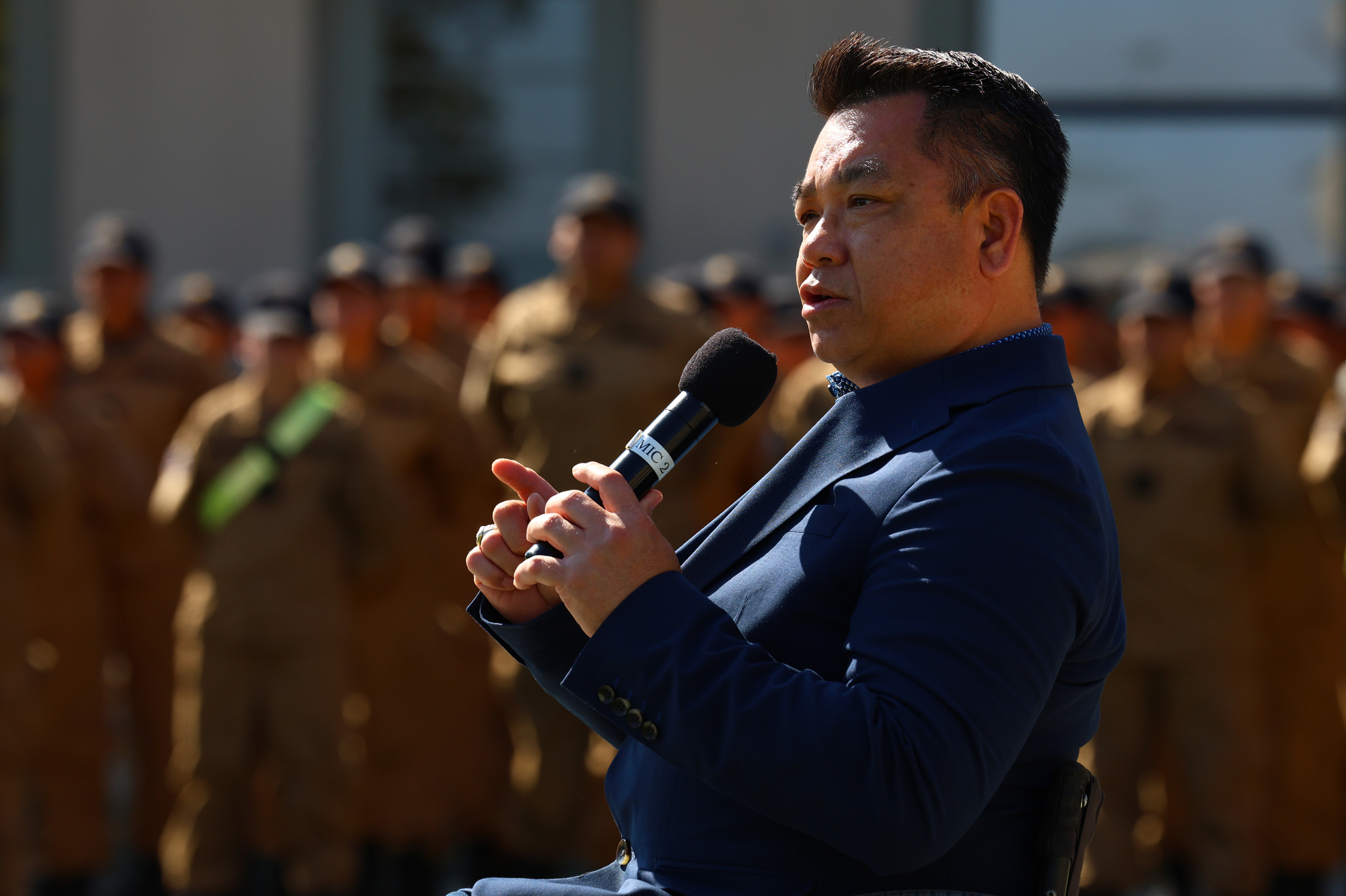 Dr. Stefan Bean speaks into a microphone during a ceremony at Joint Forces Training Base in Los Alamitos, where Sunburst Youth Academy received OCDE’s inaugural School Impact Award recognizing innovation and student success.