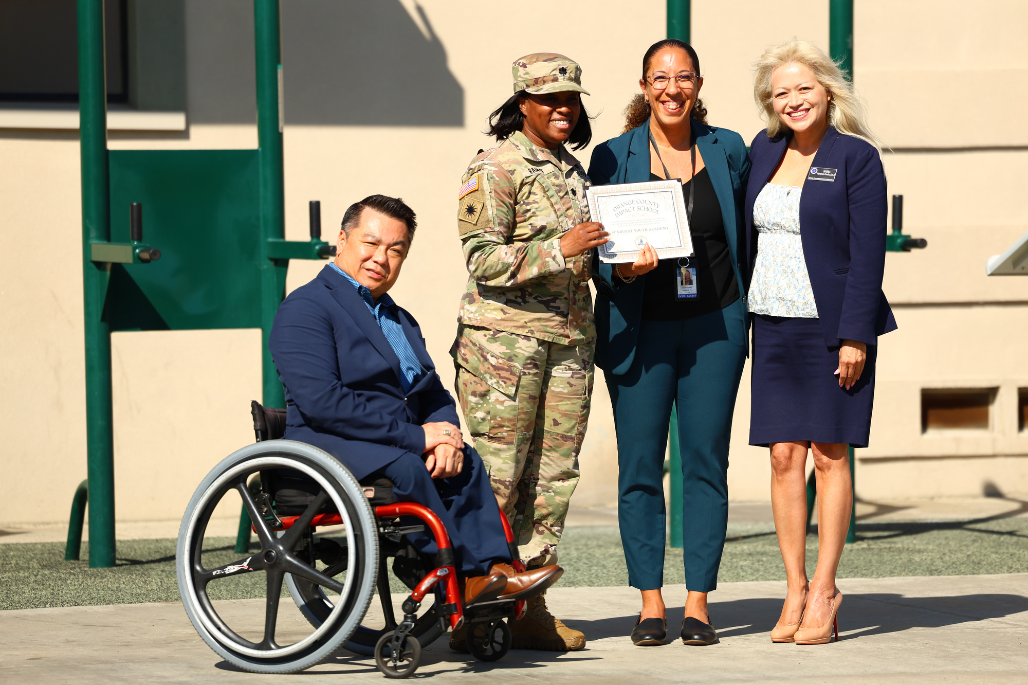 Dr. Stefan Bean, Lt. Col. Sarah Rambo, Dinah Ismail, and Dr. Maria Martinez-Poulin pose with a certificate during a ceremony at Joint Forces Training Base in Los Alamitos, where Sunburst Youth Academy was recognized as one of 12 campuses to receive OCDE’s inaugural School Impact Award.