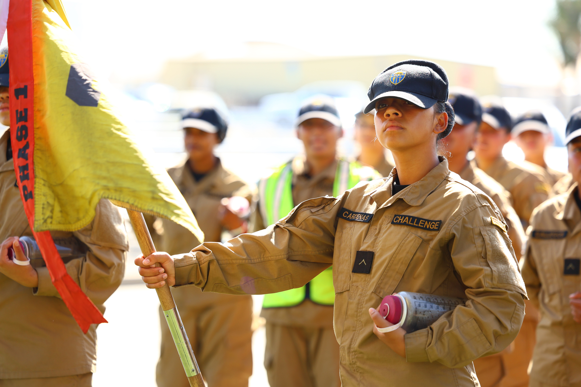 A Sunburst Youth Academy cadet holds a yellow flag during a ceremony at Joint Forces Training Base in Los Alamitos, where the academy was recognized as one of 12 campuses to receive OCDE’s inaugural School Impact Award.