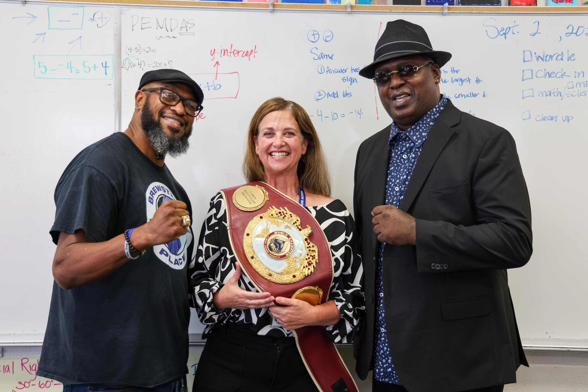 Fischer School teacher Lisa Mulkerin-Carey welcomes former heavyweight boxers James "Buster" Douglas and Lamon Brewster to speak with her students.
