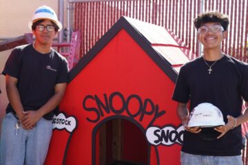 Estancia High School students stand beside a rebuilt Snoopy doghouse they helped construct as part of a project supporting Costa Mesa’s annual Snoopy House display.