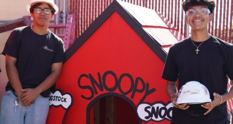 Estancia High School students stand beside a rebuilt Snoopy doghouse they helped construct as part of a project supporting Costa Mesa’s annual Snoopy House display.