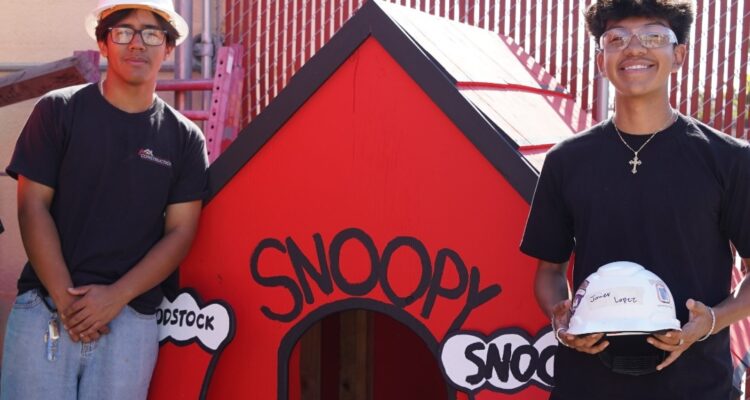 Estancia High School students stand beside a rebuilt Snoopy doghouse they helped construct as part of a project supporting Costa Mesa’s annual Snoopy House display.