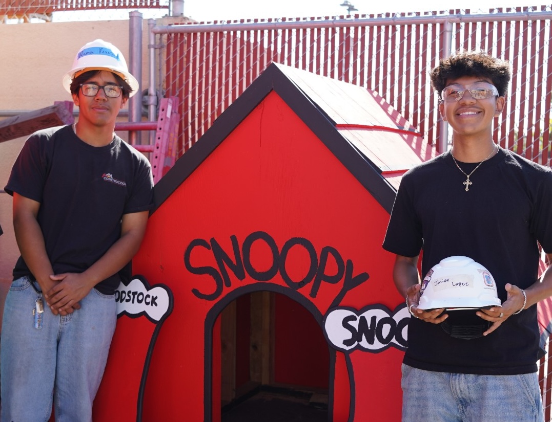 Estancia High School students stand beside a rebuilt Snoopy doghouse they helped construct as part of a project supporting Costa Mesa’s annual Snoopy House display.