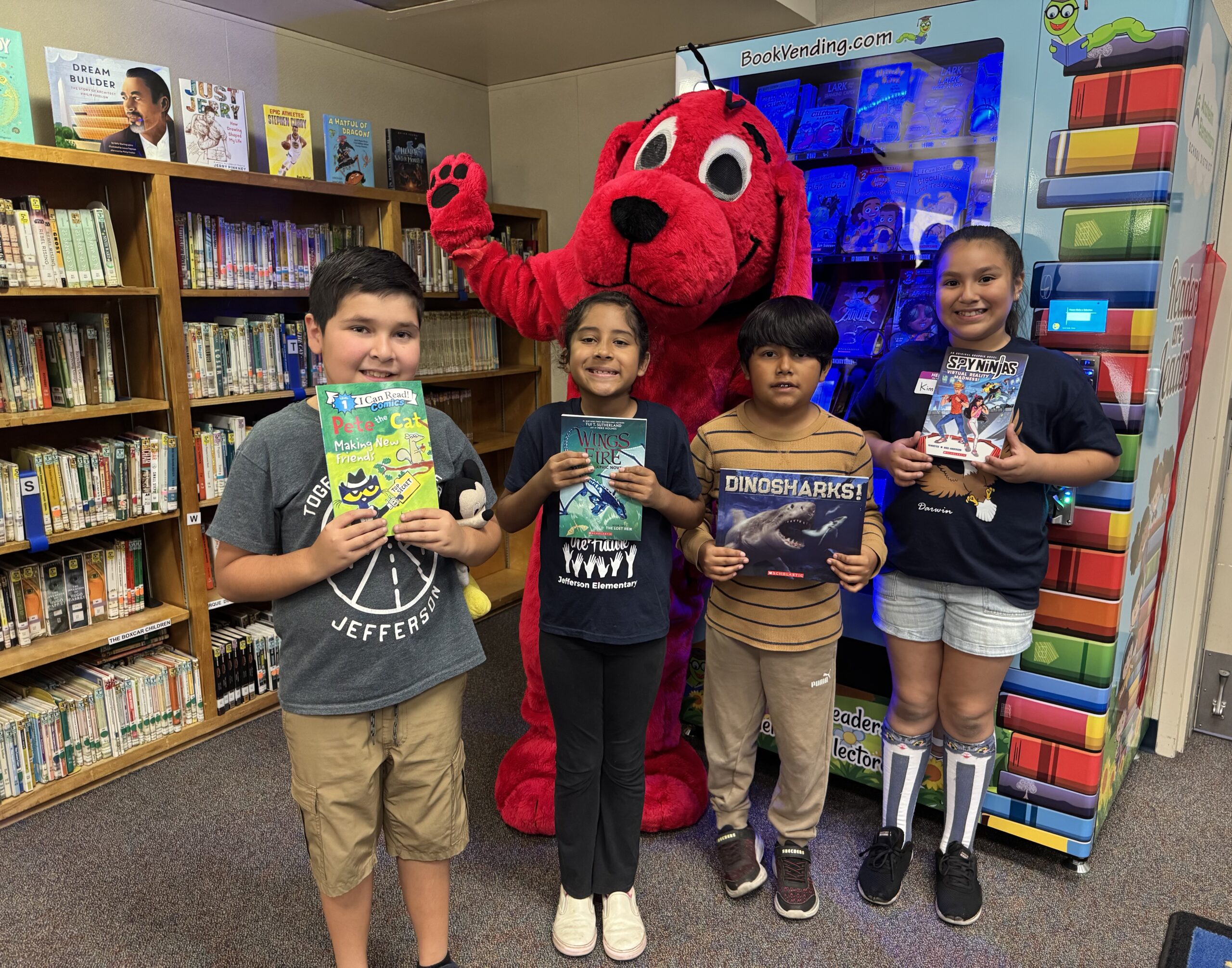 Clifford the Big Red Dog joins students (from left) Jaxson Serna, Rosalina Ricaurte, Andres Guerrero and Kimberly Arce in front of a new book vending machine at Thomas Jefferson Elementary in Anaheim.