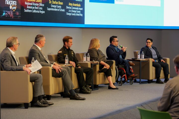 Six panelists sit onstage during a disaster preparedness discussion at the Be Prepared OC Summit, including leaders from education, public safety and community organizations.