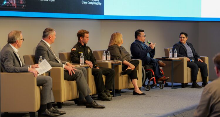 Six panelists sit onstage during a disaster preparedness discussion at the Be Prepared OC Summit, including leaders from education, public safety and community organizations.