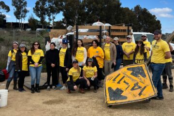 Volunteers pose beside a truck filled with bags of trash collected during last year’s Inside the Outdoors MLK Day of Service at Upper Newport Bay.