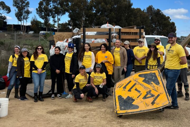 Volunteers pose beside a truck filled with bags of trash collected during last year’s Inside the Outdoors MLK Day of Service at Upper Newport Bay.