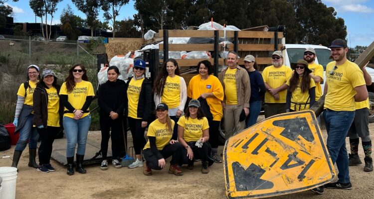 Volunteers pose beside a truck filled with bags of trash collected during last year’s Inside the Outdoors MLK Day of Service at Upper Newport Bay.