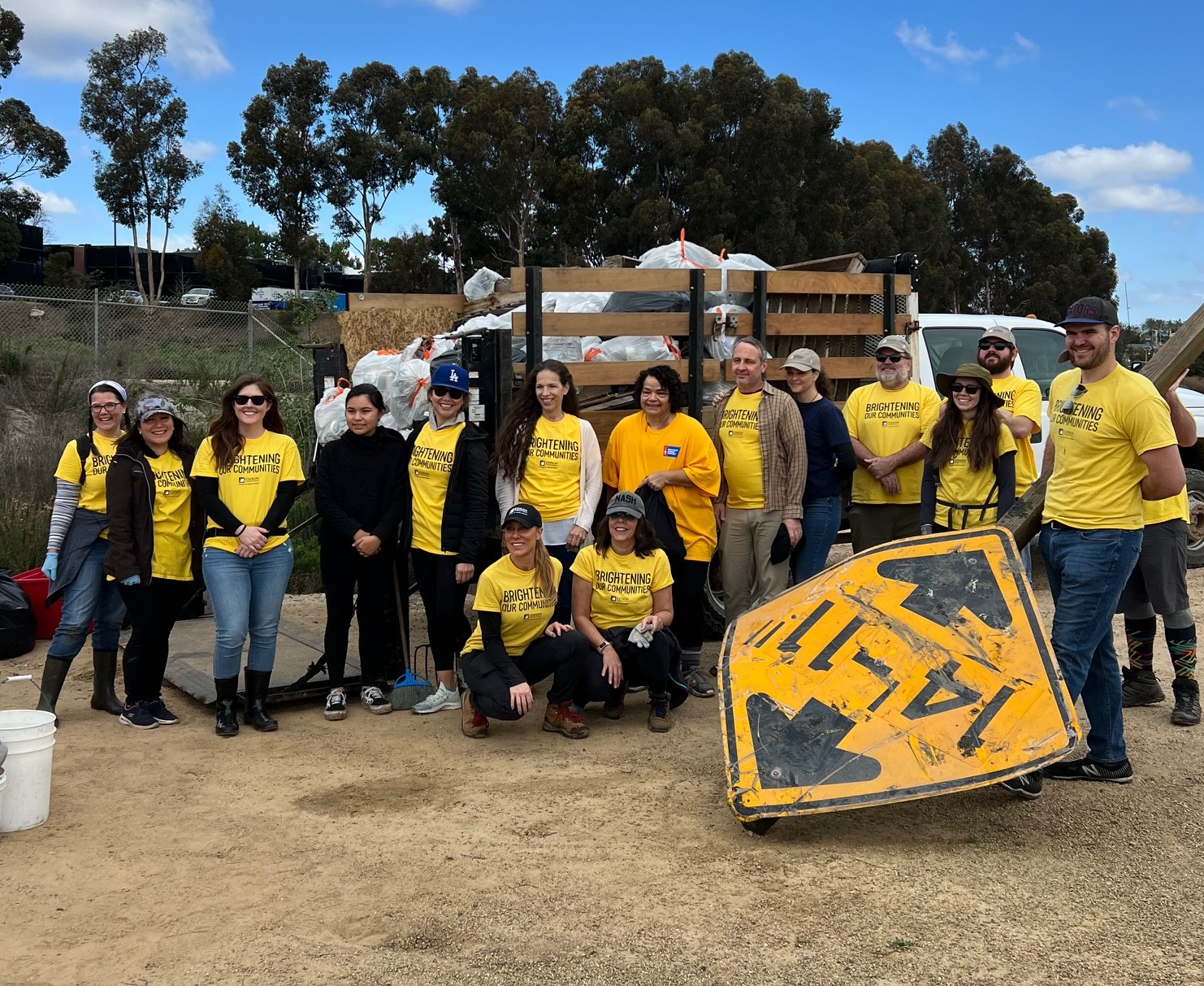 Volunteers pose beside a truck filled with bags of trash collected during last year’s Inside the Outdoors MLK Day of Service at Upper Newport Bay.