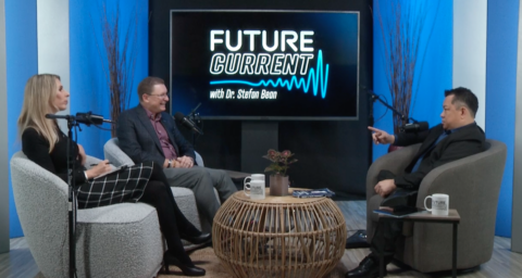 Dr. Stefan Bean speaks with Eric L. Goodman and Lainie Rowell on the FutureCurrent podcast set, with microphones and chairs arranged for a recorded conversation.