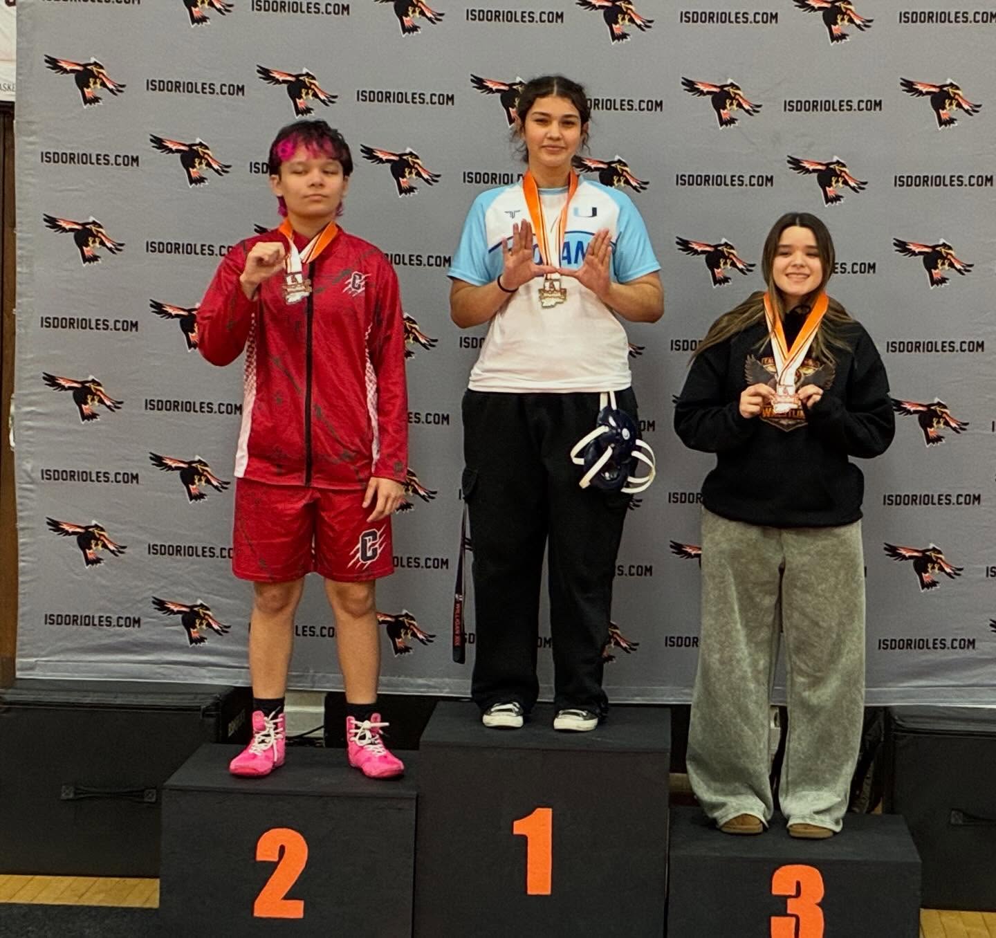 Emma Echeverria stands at the top of the podium as she receives her first place medal.