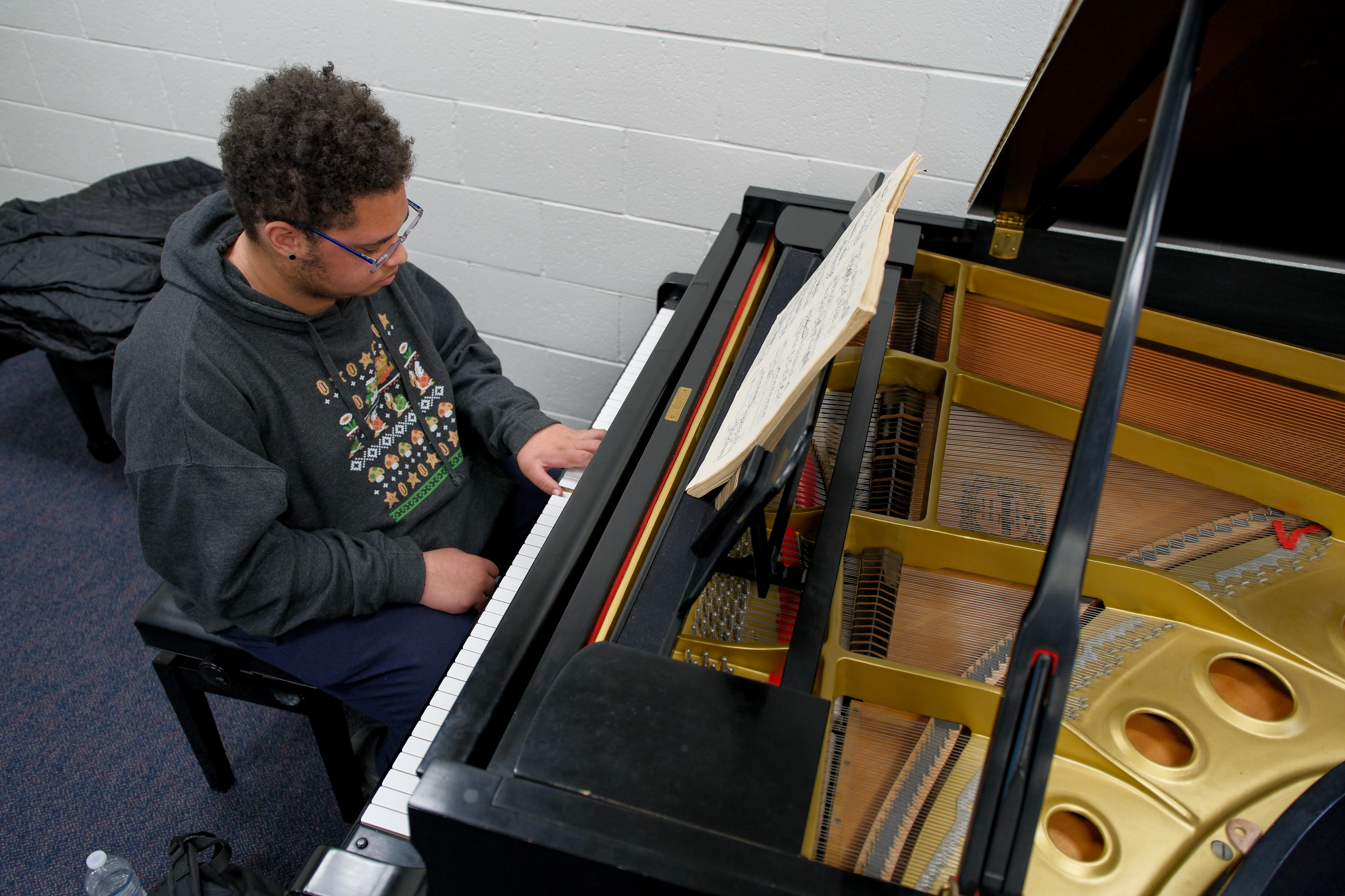 An OC high school student learns how to play a couple chords in the piano lab session at the OC College and Career Pathways in the Arts event.